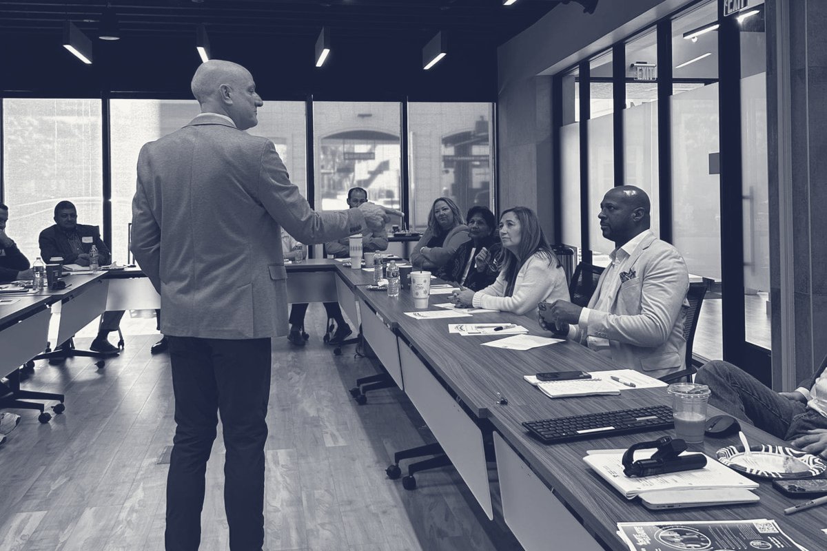 Matt George leading a session with a table of executives