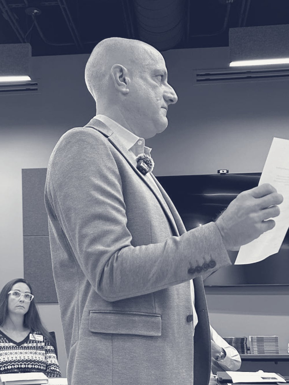 Matt George reading from a page while leading an Impact Boardroom session